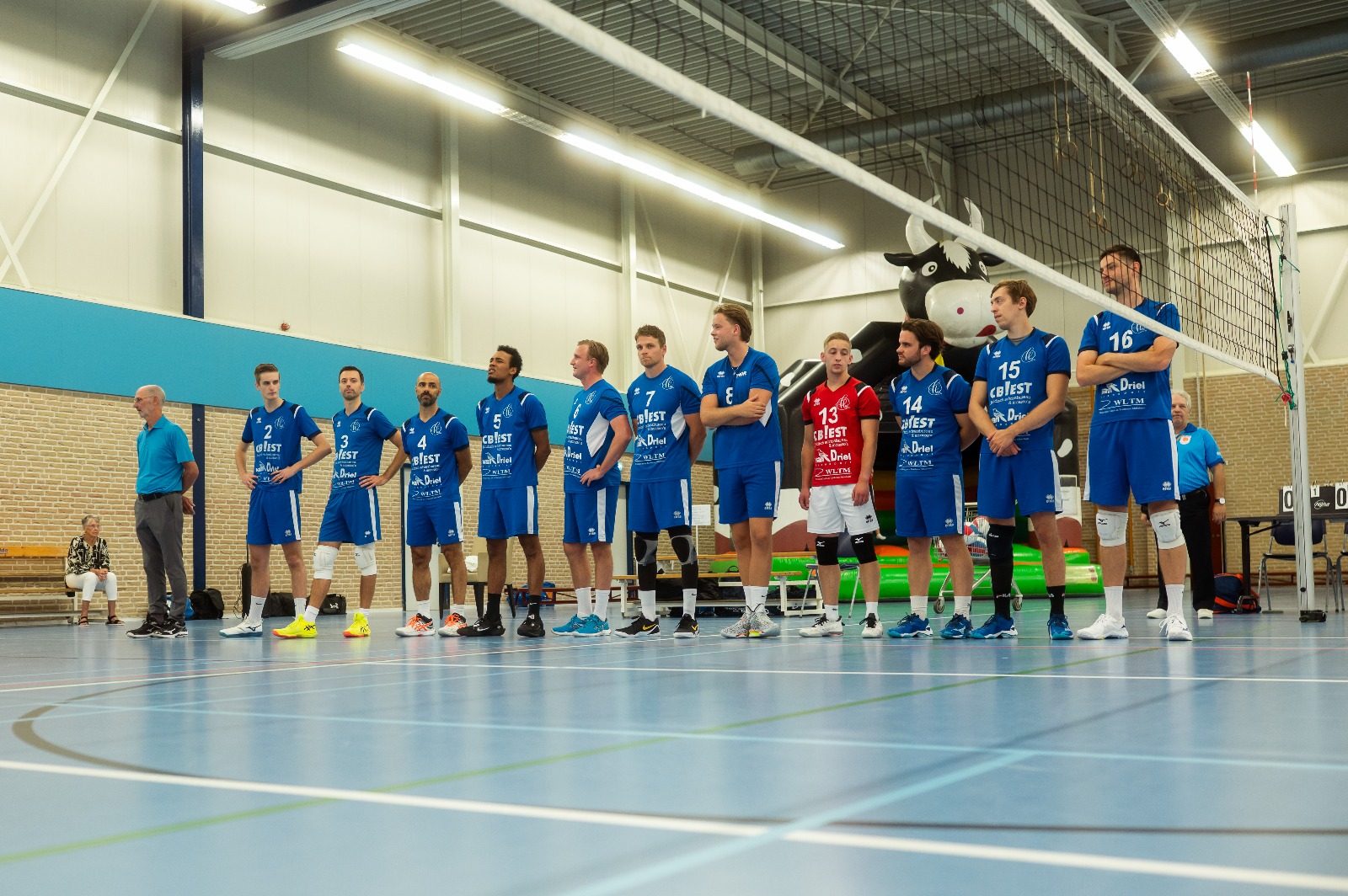 Heren 1 staat opgesteld langs het veld in Sporthal De Waard